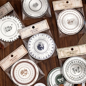 Vintage circular stickers 24pcs with celestial and botanical themes on dark wood