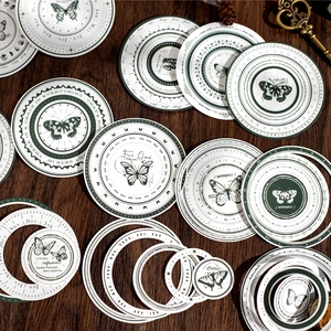 Vintage round decorative stickers with butterflies and calendar designs on dark wood