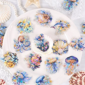 Holographic PET ocean stickers featuring mermaids and sea life on white ceramic plate