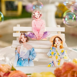 Chic girl PET stickers with three fashionable outfits on a miniature wooden bench