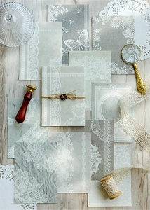 Detailansicht von dekorativem Scrapbooking-Papier mit Spitzenmuster auf hellem Holzgrund