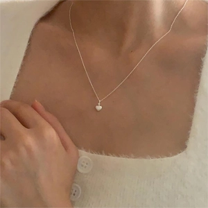 Minimalist 925 sterling silver heart pendant necklace shown on a model's neck