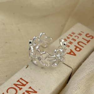 Close-up of S925 sterling silver hollow flower ring with white zircon stones on petal centers