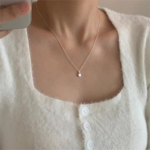Minimalist 925 sterling silver heart necklace shown on model with cozy white sweater