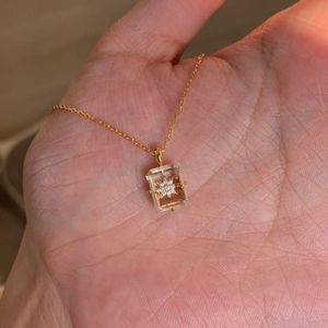 Macro shot of gold rectangle crystal pendant with eight-pointed star and tiny diamonds