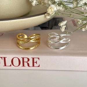 Close-up of gold and silver S925 sterling silver multilayer rings on a book