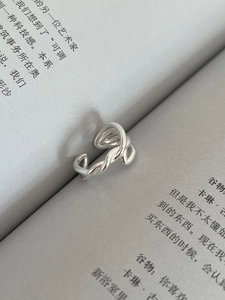 Detailed view of silver twisted crossover ring placed inside a book binding