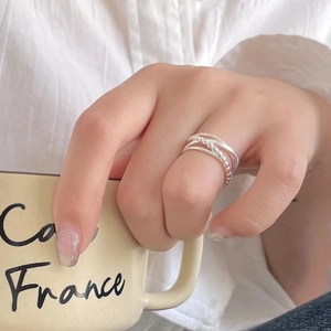 Detail of S925 silver layered ring with bead texture shown on hand holding coffee cup