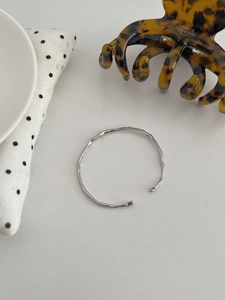 Detail of S925 silver irregular wavy cuff bracelet with polished hammered texture