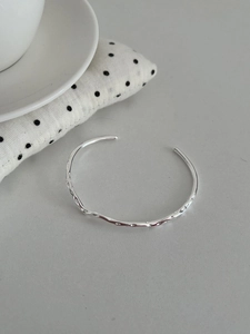 Macro detail of S925 sterling silver cuff with liquid metal hammered texture