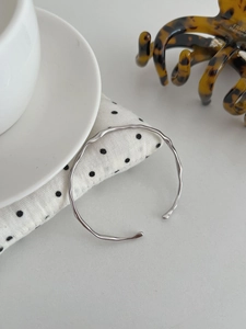 Detail of irregular wave texture on polished S925 silver cuff bracelet for women