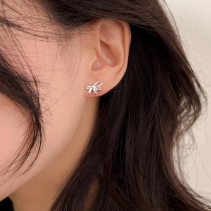 Close-up of S925 silver bow stud earrings with a 3D ribbon twist design on ear