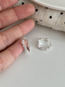 Gros plan de créoles torsadées en argent S925 avec micro-incrustations de zircons