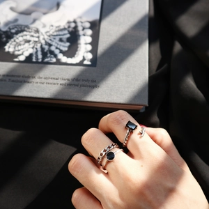 Gros plan sur trois bagues vintage en argent S925 avec pierres noires et maillons