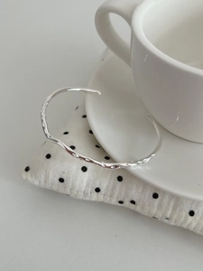 Detailed macro view of S925 sterling silver cuff with irregular hammered metal texture