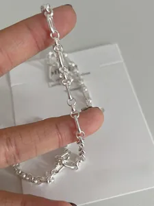 Macro detail of S925 sterling silver chain link necklace showing polished texture