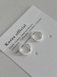 Vue macro de créoles minimalistes en argent sterling S925 avec une finition polie