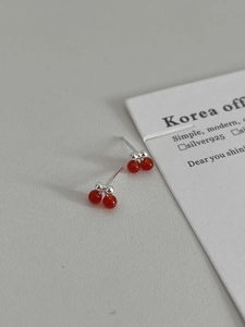 Macro view of S925 silver cherry stud earrings with translucent deep red resin fruit