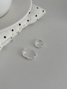 Détail de boucles d'oreilles créoles torsadées en argent S925 serties de zircons brillants
