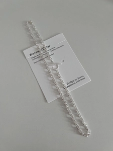 Macro detail of the S925 sterling silver OT toggle chain necklace on a display card