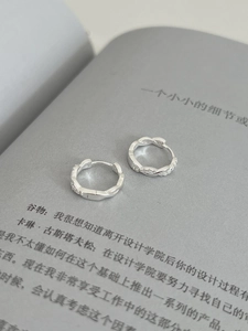 Gros plan de boucles d'oreilles torsadées en argent serties de petits diamants