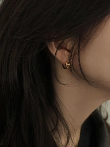 Minimalist 925 sterling silver golden pig nose hoop earrings worn on female model ear