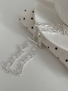 Detailed view of S925 silver link chain necklace with OT toggle clasp on ceramic cup