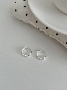 Vue détaillée des créoles en argent sterling S925 avec texture métallique fluide irrégulière