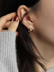 Boucles d'oreilles clous carrées en argent S925 plaqué or portées par un mannequin chic