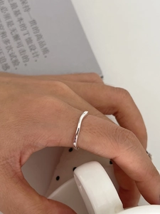 Close-up of a minimalist S925 sterling silver irregular wave ring on a model hand