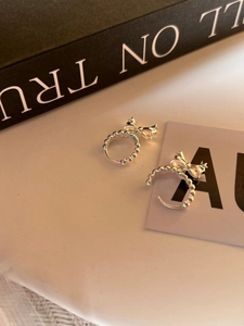 Gros plan détaillé des boucles d'oreilles nœud en argent sterling 925 avec texture perlée