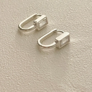 Détail macro de boucles d'oreilles créoles en argent avec zircone cubique rectangulaire