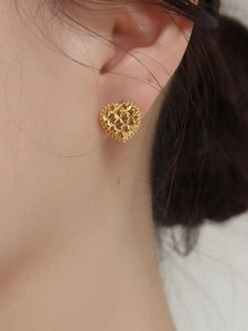 925 silver heart stud earrings in gold with geometric quilted pattern on model