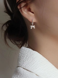 Boucles d'oreilles nœud en argent sterling 925 pour femme, portées avec élégance par un mannequin