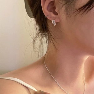 Gros plan d'un collier en argent 925 et de boucles d'oreilles en zircon sur un mannequin