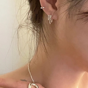 Gros plan de boucles d'oreilles carrées en argent 925 et collier sur le mannequin