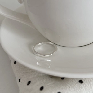 Minimalist S925 sterling silver ring with irregular wave texture in a ceramic dish