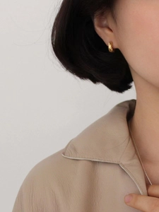 Elegant gold twisted hoop earrings with vintage texture on female model with chic necklace