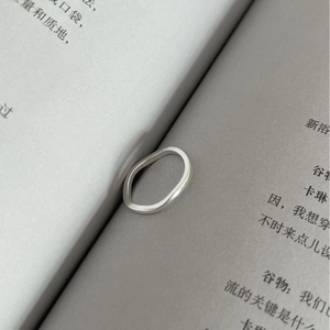 Minimalist S925 sterling silver square wavy ring displayed in an artistic book setting