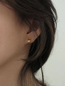 Close-up of elegant double C-shaped gold earrings on model for a minimalist chic look