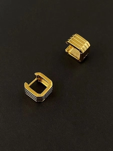 Close-up of golden square hoop earrings in 925 silver with triple parallel line texture