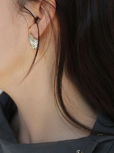 Close-up of vintage 925 sterling silver shell-shaped earrings worn by a model