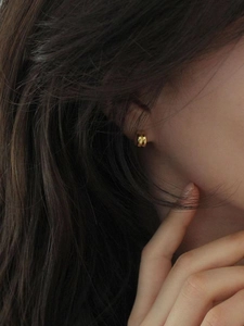 Close-up of minimalist double golden hoops earrings on a model for a chic look