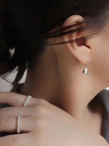 Minimalist 925 sterling silver teardrop earrings on model with matching bead rings