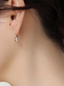 S925 sterling silver teardrop hook earrings with minimalist polished finish on model