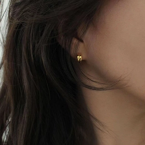 Minimalist gold 925 sterling silver C-shaped hoop earrings worn by a female model