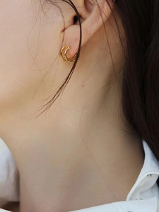 Boucles d'oreilles créoles dorées à double couche portées par un mannequin chic
