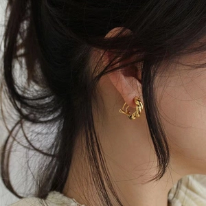 Elegant 925 silver gold-plated twisted C-shape hoop earrings on model profile view