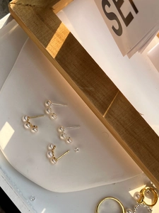 Detailed shot of 925 silver pearl stud earrings in gold and silver finishes
