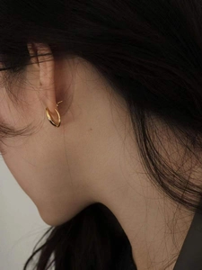 Gros plan de boucles d'oreilles créoles torsadées en argent 925 plaqué or 18 carats